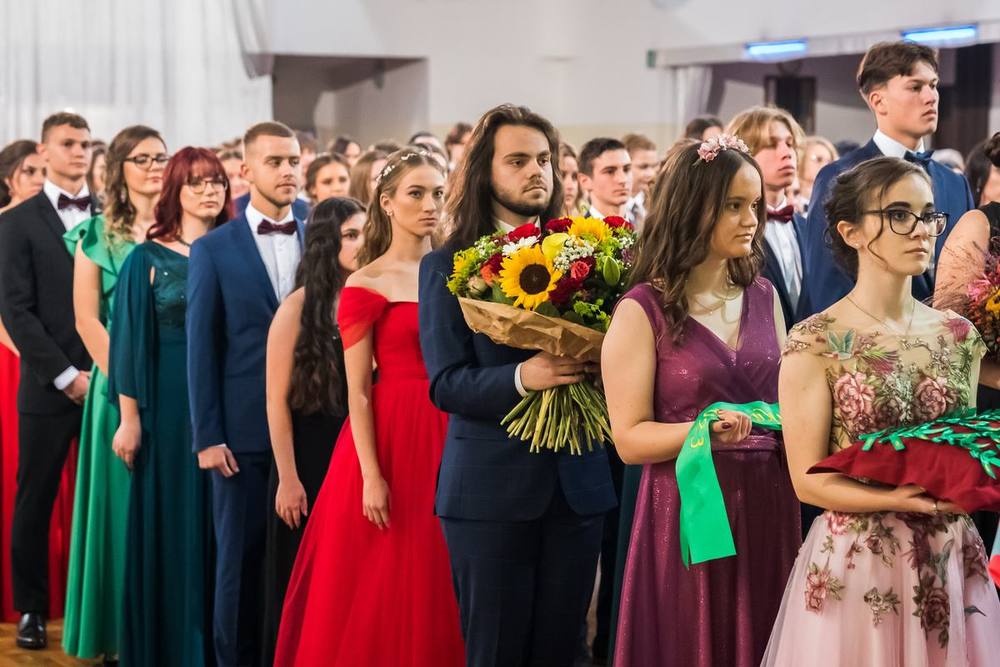 Maturanti s kyticou a stužkami na stužkovej slávnosti