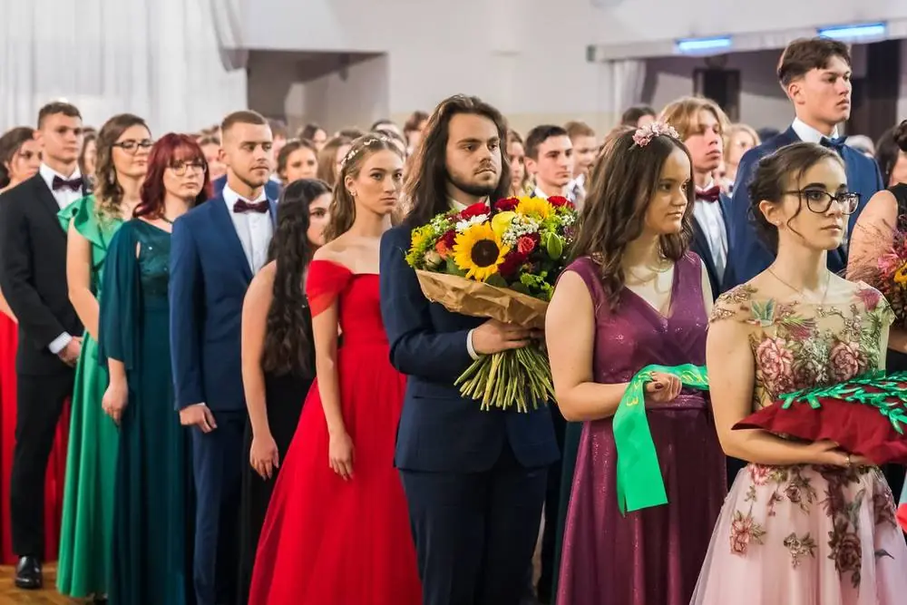 Maturanti s kyticou a stužkami na stužkovej slávnosti