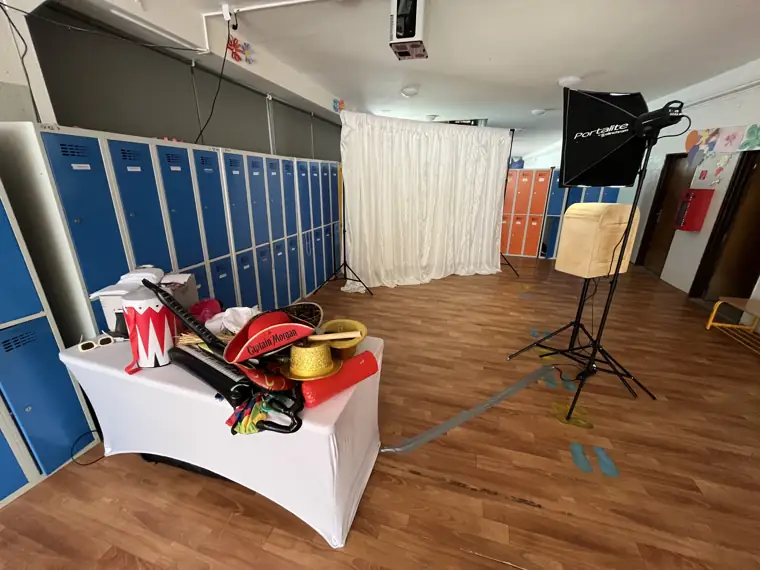 Fotobúdka s bielym záclonovým pozadím a rekvizitami nachystaná v priestore